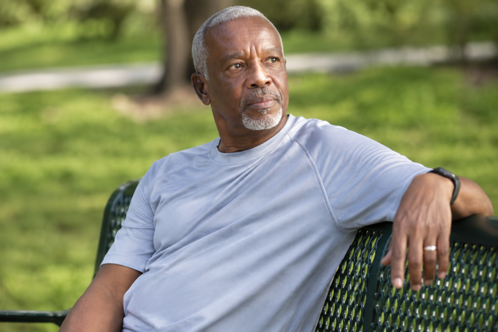 Older man resting on a park bench during a walk